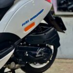 Close-up van de achterzijde van een witte scooter met Polini Evolution sticker en zichtbaar motorblok.