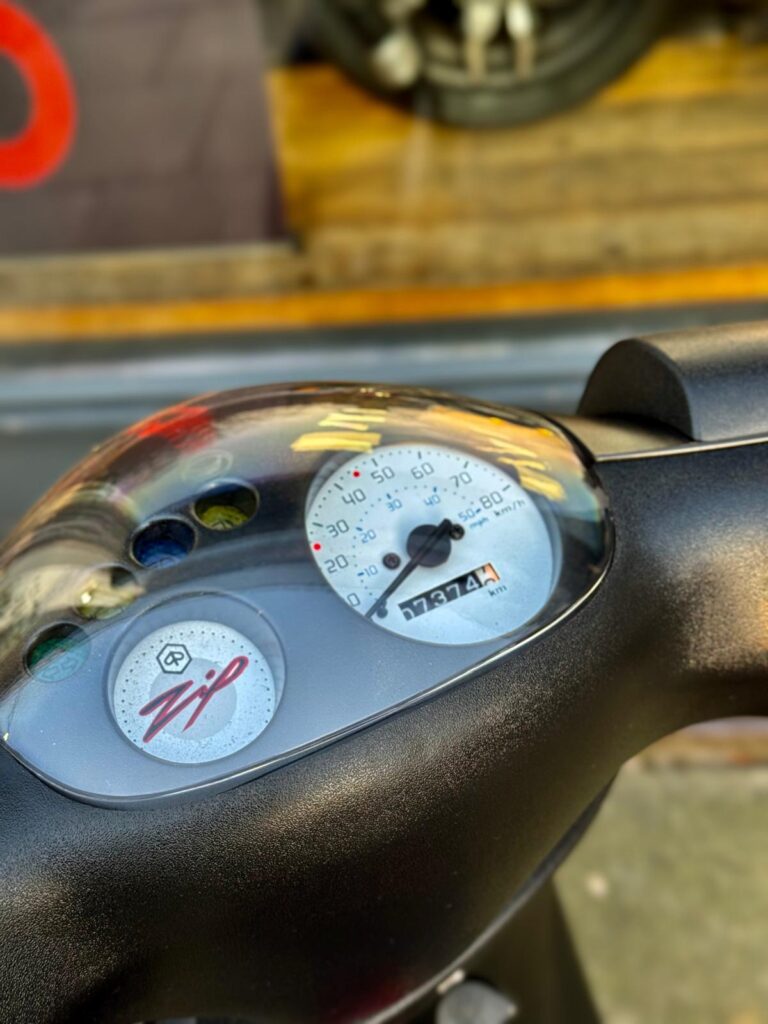Close-up van het dashboard van een scooter met snelheidsmeter en kilometerstand.