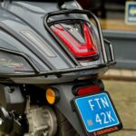 Close-up van de achterkant van een grijze GTS Palermo scooter met LED-achterlicht en blauw kenteken.