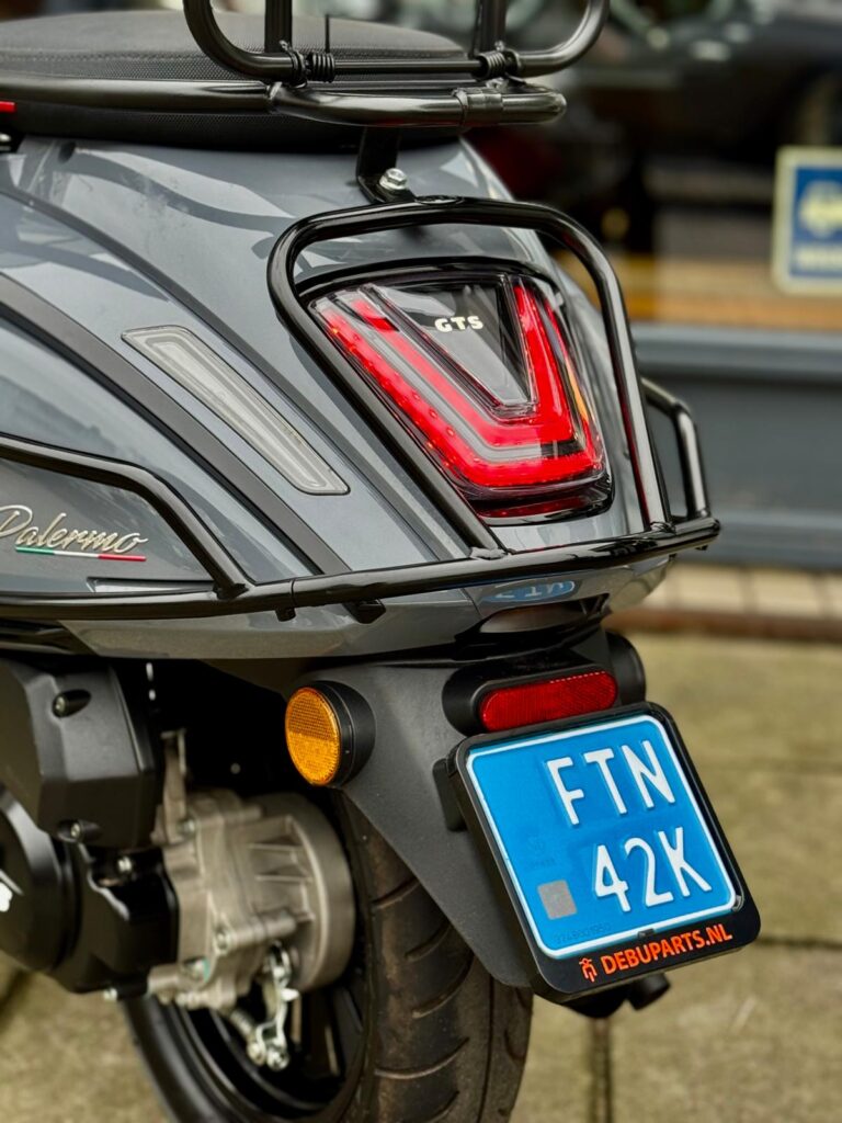 Close-up van de achterkant van een grijze GTS Palermo scooter met LED-achterlicht en blauw kenteken.