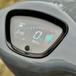 Close-up van digitaal scooterdashboard met 0 km/u, kloktijd 12:36 en 963 km op de teller.