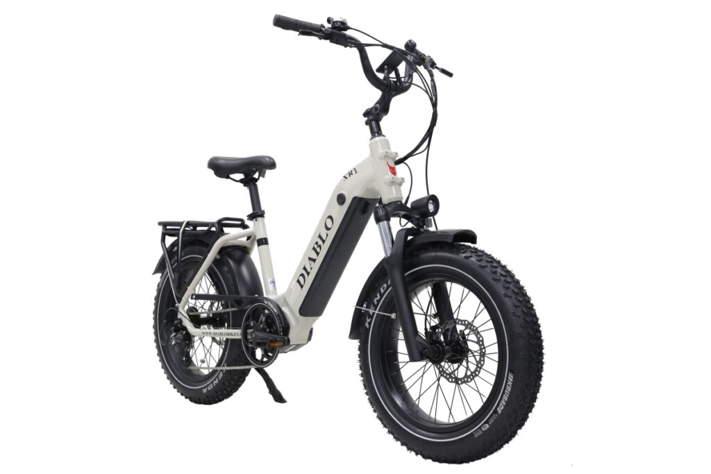 Witte elektrische fatbike met dikke banden, voorvering, koplamp en bagagedrager op witte achtergrond.