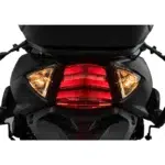 Close-up van het achterlicht met remlicht en richtingaanwijzers van een zwarte scooter.