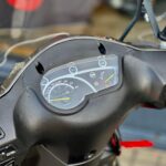 Close-up van het dashboard van een scooter met analoge snelheidsmeter en kilometerteller.