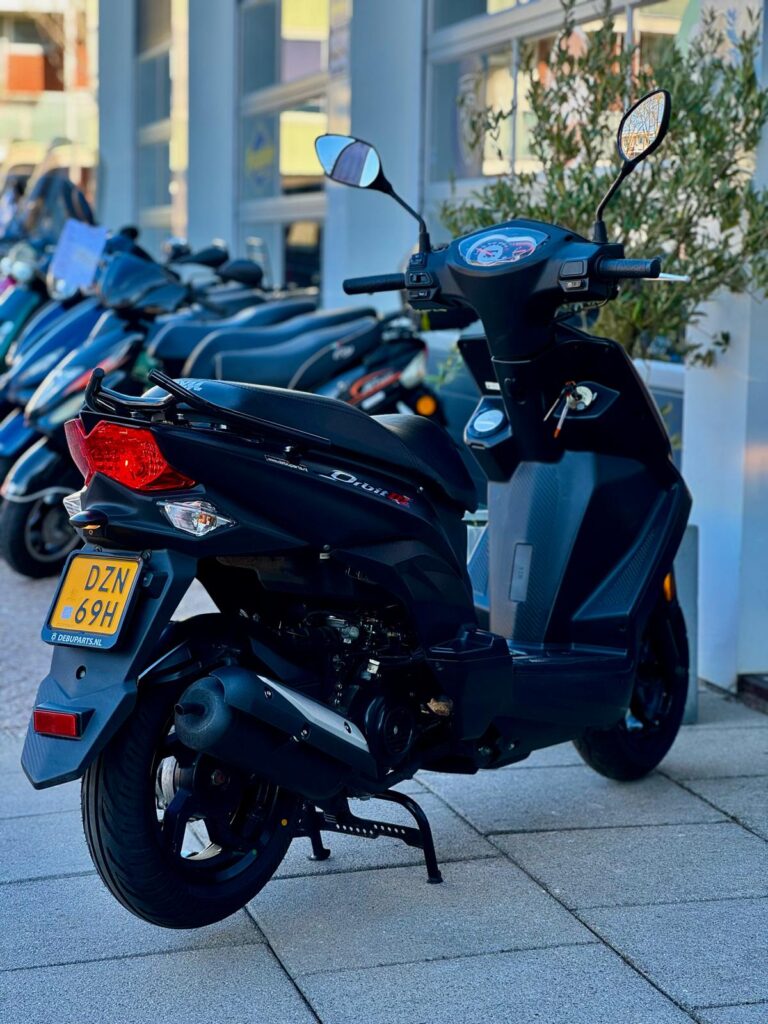 Zwarte scooter met spiegels en gele kentekenplaat, geparkeerd voor een rij scooters.