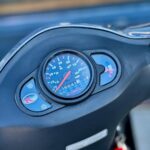 Close-up van het dashboard van een Kymco scooter met snelheidsmeter en brandstofmeter.