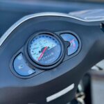 Close-up van het dashboard van een Kymco-scooter met snelheidsmeter en brandstofmeter.