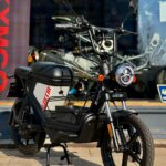 Zwarte elektrische scooter Goccia met ronde koplamp voor een etalage in de zon