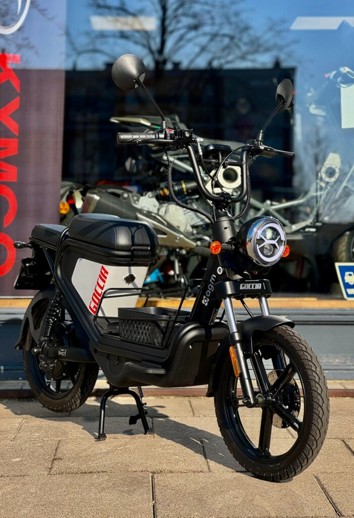 Zwarte elektrische scooter Goccia met ronde koplamp voor een etalage in de zon