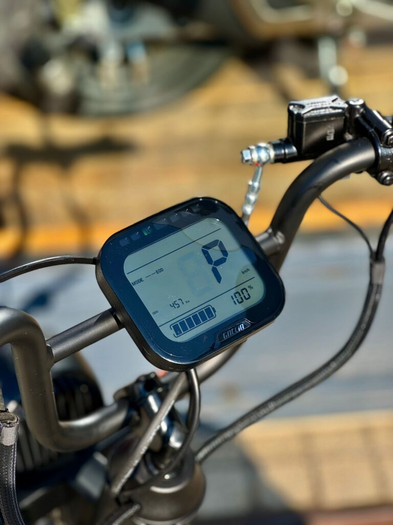 Close-up van het e-bike display op het stuur met 100% acculading in de zon.