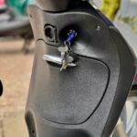 Close-up van een scooter met sleutels in het contactslot bij het stuur.