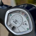 Close-up van het instrumentenpaneel van een Liberty-scooter met snelheidsmeter, kilometerteller en brandstofmeter.