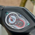Close-up van het dashboard van een scooter met snelheidsmeter en brandstofmeter.