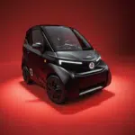 Zwarte microauto met futuristisch design en LED-lichten, gefotografeerd in rode studio