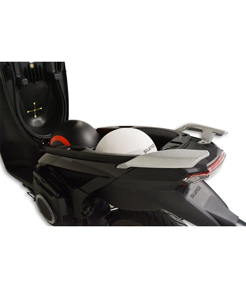 Open onderzadel-opbergruimte van een scooter met twee helmen, zwart en wit.