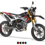 Zwart-wit-rode supermoto motorfiets met goudkleurige voorvork, zijaanzicht op witte achtergrond.