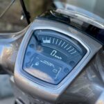Close-up van het dashboard van een scooter met digitale snelheidsmeter op 0 km/u.