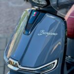 Close-up van de voorkant van een blauwe Bergamo-scooter met LED-koplampen en windscherm.