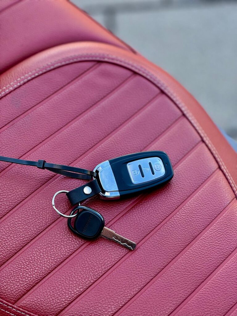 Set autosleutels met afstandsbediening op geribbelde rode leren autostoel