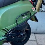 Groene AGM VX50 scooter, close-up van achterzijde met wiel en valbeugel.