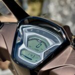 Close-up van het digitale dashboard van een scooter, met snelheidsmeter, odometer en brandstofniveau.