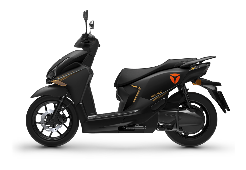 Zijaanzicht van een matzwarte scooter met oranje accenten en schijfrem, op witte achtergrond.
