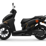 Zijaanzicht van een matzwarte scooter met oranje accenten en schijfrem, op witte achtergrond.