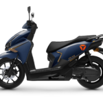 Donkerblauwe moderne scooter in zijaanzicht met oranje accenten en zwarte wielen, vrijstaand op witte achtergrond.