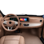 Modern beige auto-interieur met stuur, digitaal dashboard en touchscreen.