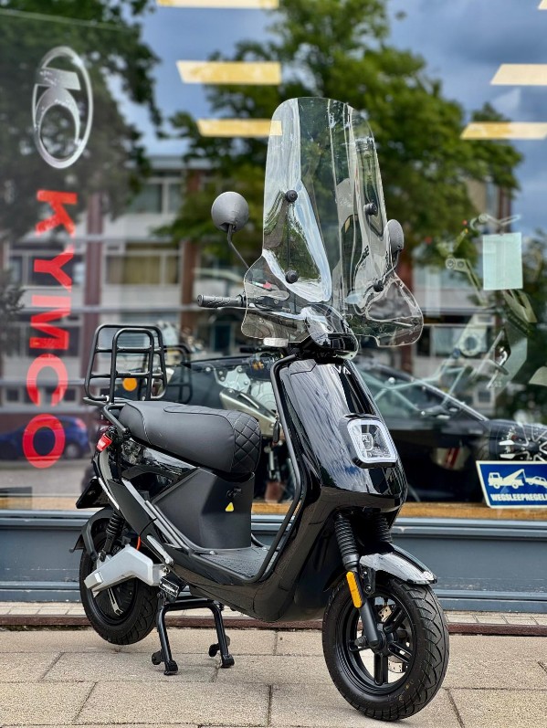 Zwarte elektrische scooter met hoog windscherm voor etalage van Kymco-dealer.
