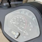 Close-up van het dashboard van een scooter met snelheidsmeter, brandstof- en temperatuurmeter.