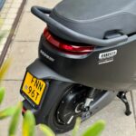 Achterzijde van een zwarte Segway E110SE elektrische scooter met geel NL-kenteken.