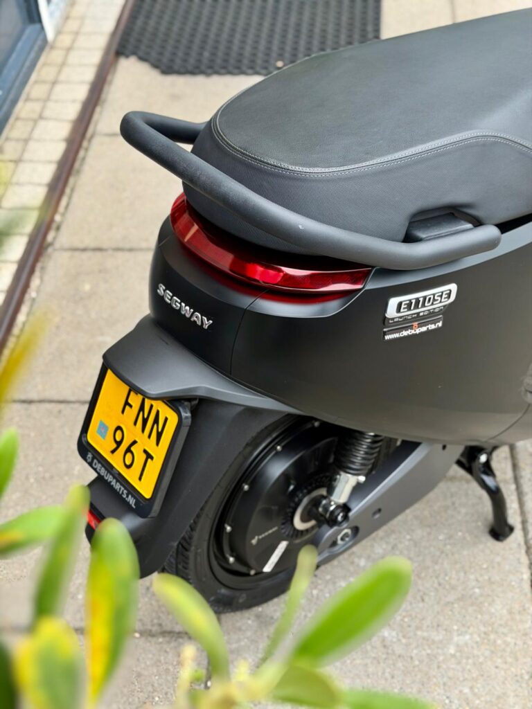 Achterzijde van een zwarte Segway E110SE elektrische scooter met geel NL-kenteken.