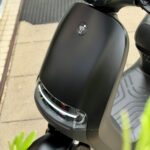Close-up van de voorkant van een matzwarte elektrische scooter met LED-koplamp.