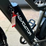 Close-up van de accu in het frame van een zwarte Navigator e-bike met sleutelhanger.