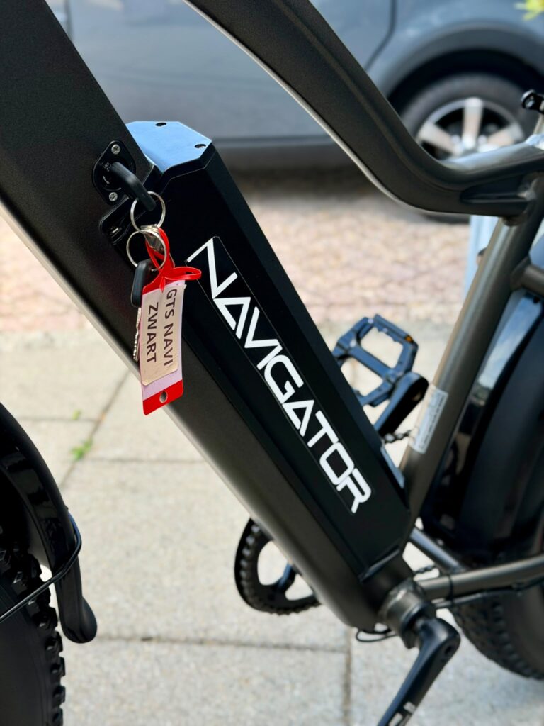 Close-up van de accu in het frame van een zwarte Navigator e-bike met sleutelhanger.