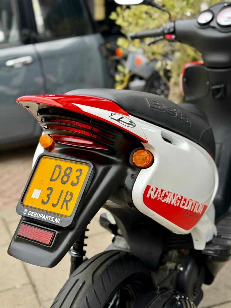 Achterkant van een witte-rode Beta Racing Edition scooter met gele NL-kentekenplaat.